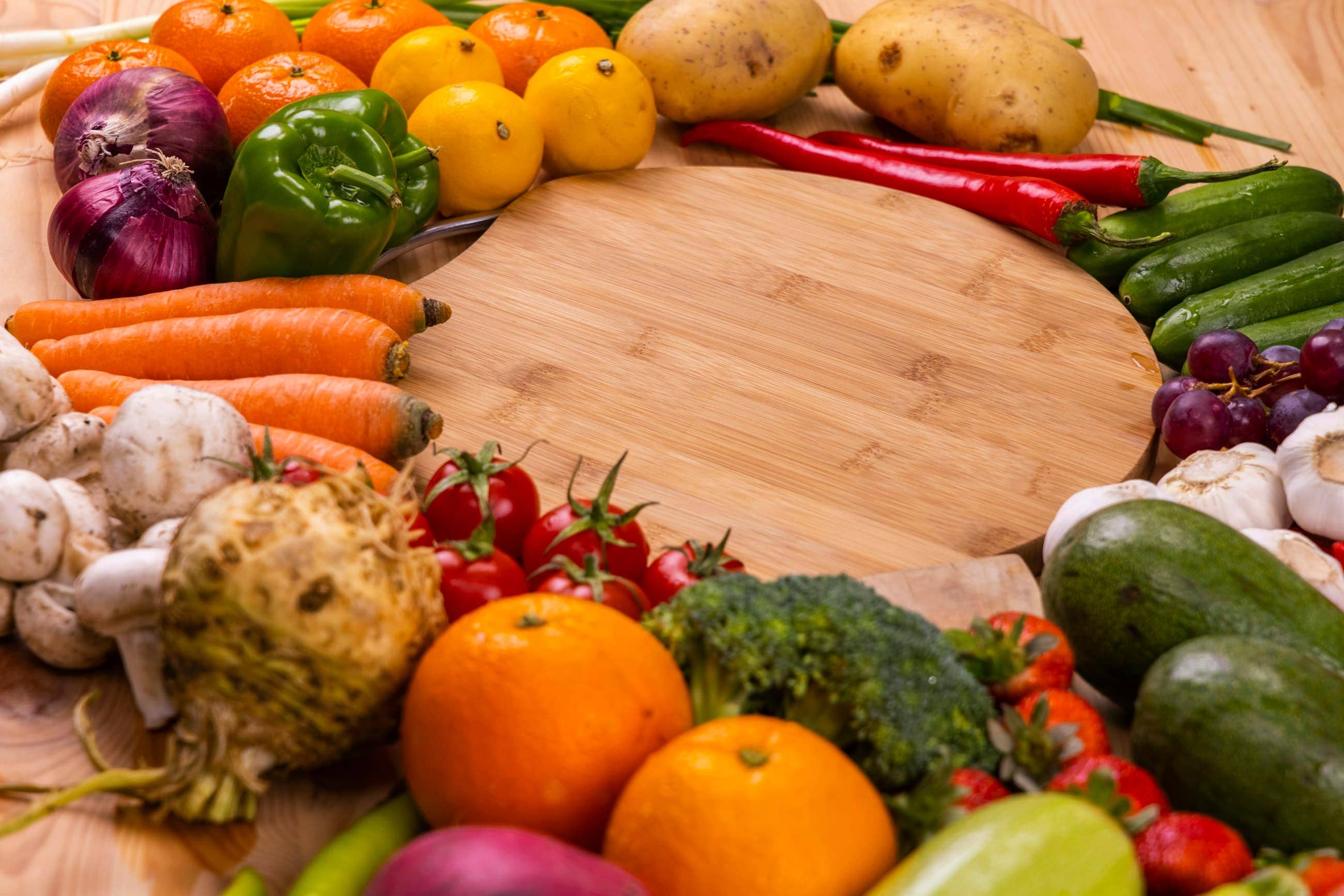 Un assortiment de légumes frais, oranges et verts, disposés sur une table en bois